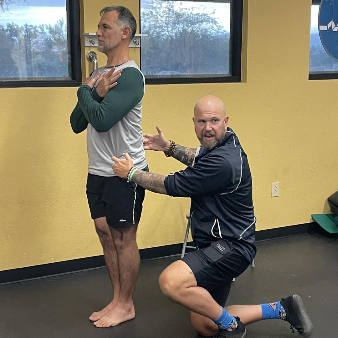 Practitioner assessing hip alignment on standing subject