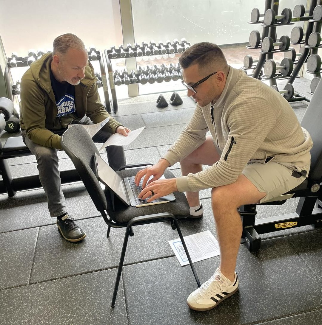 Reviewing protocols and case studies on laptop in London gym